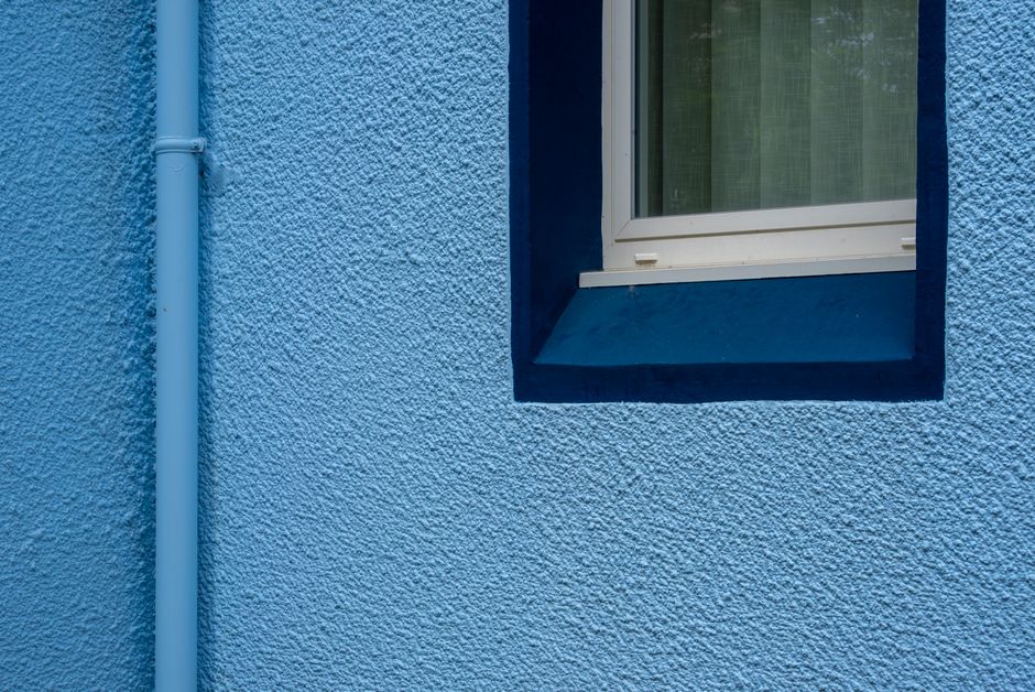 A painted house exterior with window trim and a door