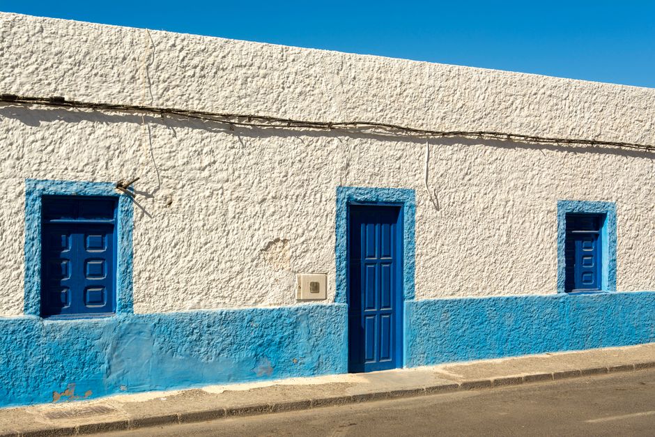 A painted house exterior with window trim and a door